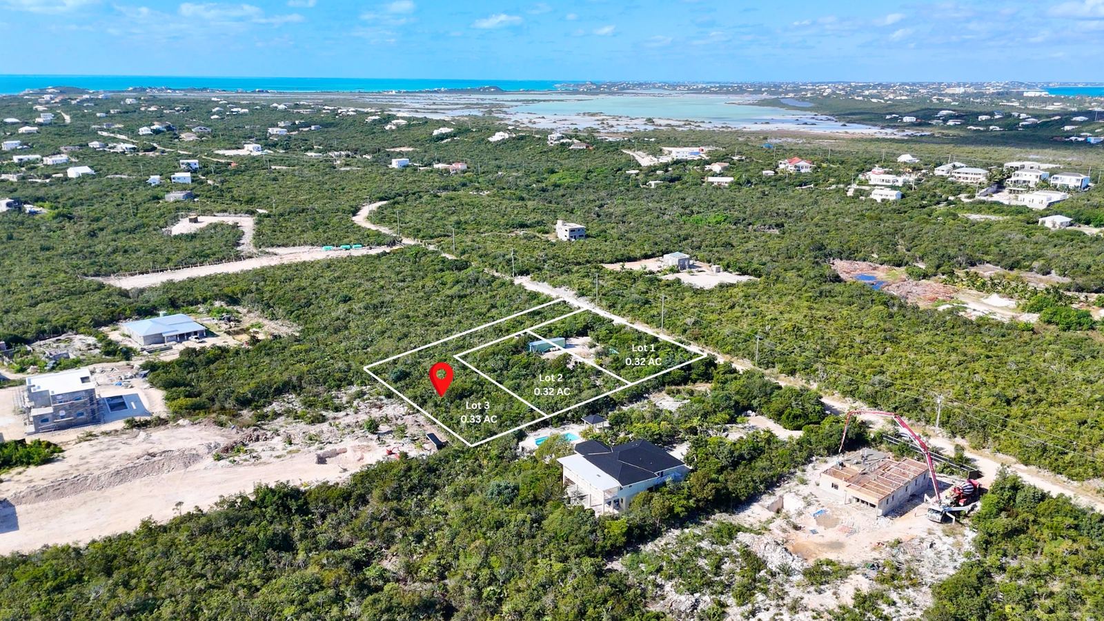 The three homesites among finished villas and new homes going up in Long Bay Hills